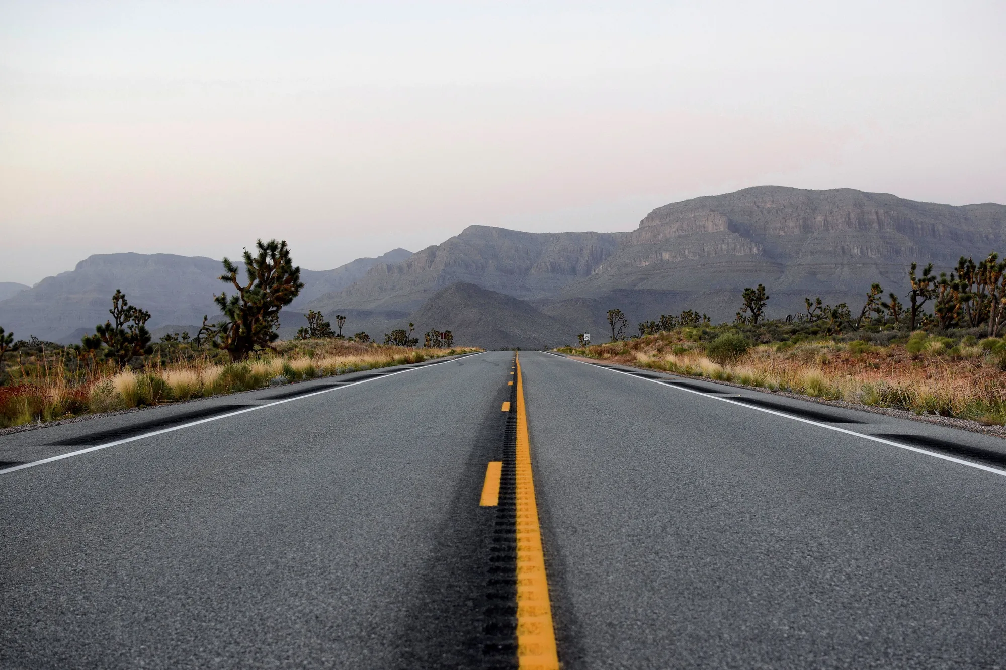 A two-lane highway running toward desert mountains