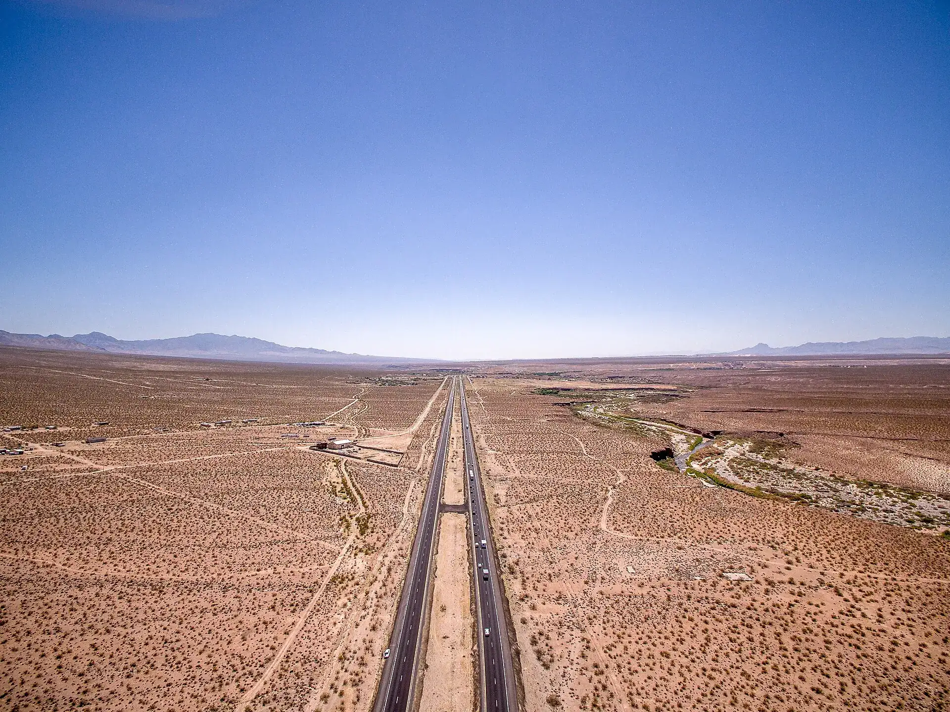 Aerial view of a long straight interstate crossing the Arizona desert